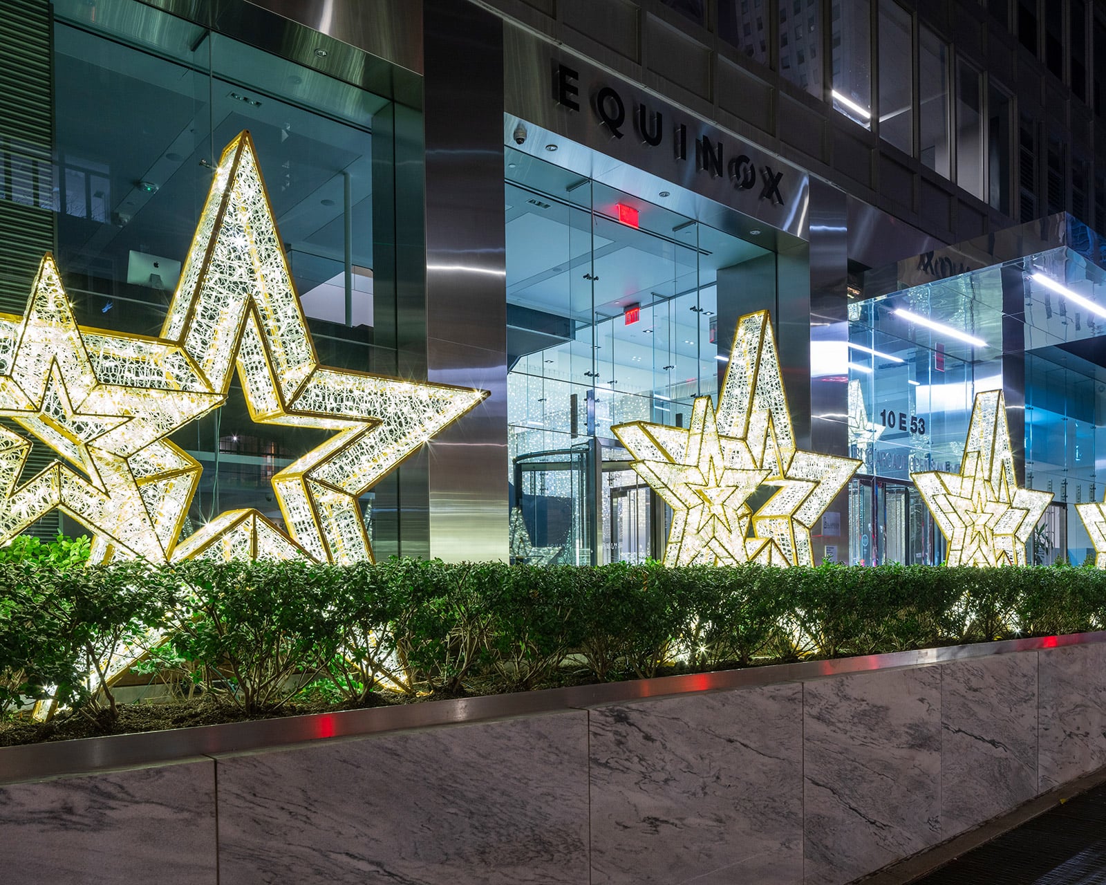 Cambridge portfolio showing illuminated holiday stars outside a contemporary retail storefront for hotels in Queens